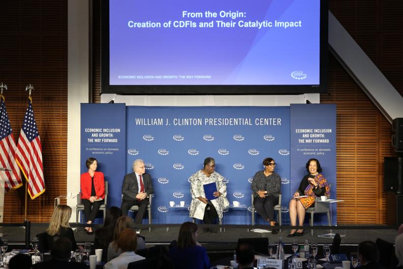 A panel of professionals speaking on stage at the Clinton Presidential Center for a discussion titled “Economic Inclusion and Growth: The Way Forward.”