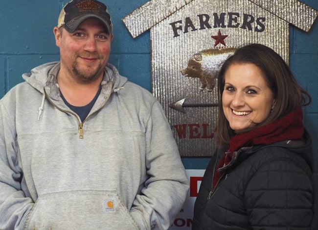 A smiling man and a woman stand in front of a sign. They are owners of Windham Butcher Shot in Windham, Maine, which received financing from CDFI CEI.