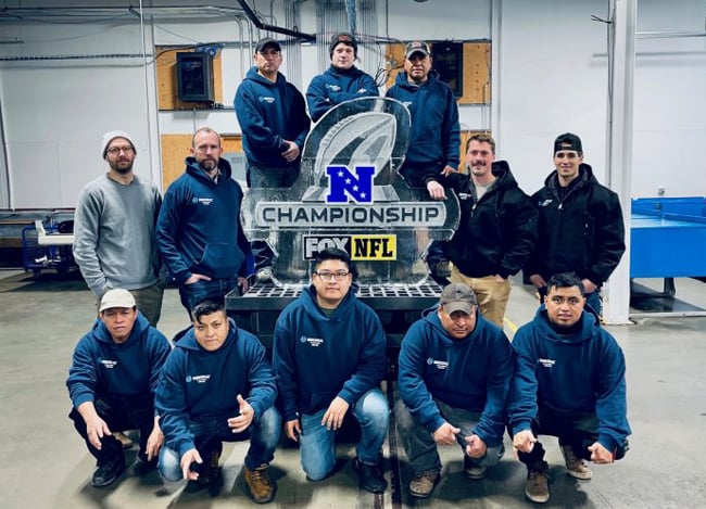 Employees at Minnesota Ice, known as the world’s largest manufacturer of sculpture-grade ice, stand in front of an ice sculpture.