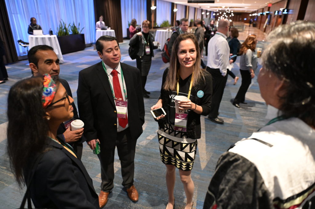 A group of people talking to each other at a conference