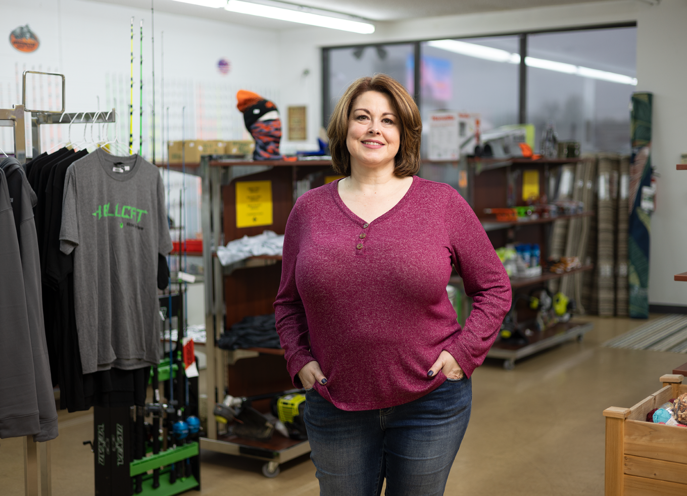 Angie Dingess, Co-Founder of AJ's Mercantile and Tackle Box, stands smiling in her store.