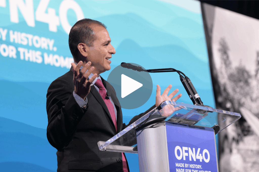 A man giving a speech at a podium at OFN's 2024 conference.