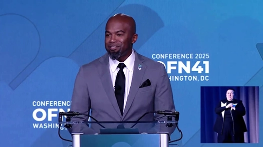 Harry Pettigrew behind a podium delivering opening remarks