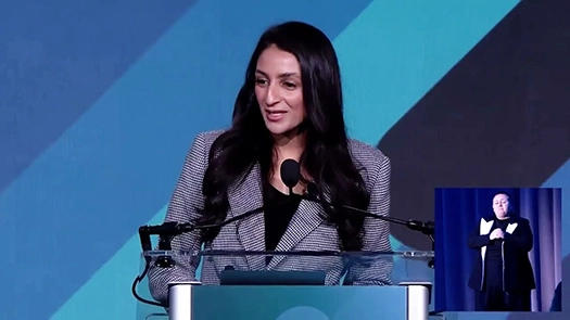 Woman standing behind podium talking