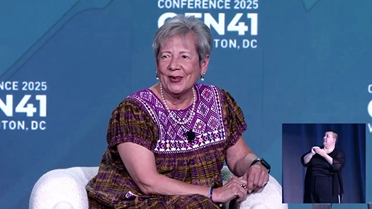 Woman sitting on couch talking during thursday plenary