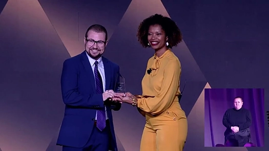 Man and woman posing with an award